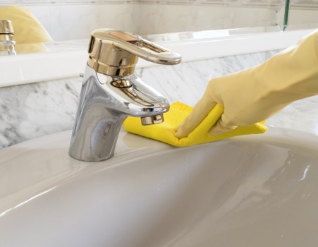 Domestic cleaner tidying a kitchen in a Richmonduponthames home
